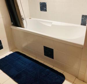 波城Magnifique Loft rénové-Quartier Culturel - Bureau的浴室设有白色浴缸和蓝色地毯。