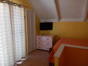 弗利盖特湾希罗夫茨海滩上酒店的一间卧室配有一张床和一个带电视的梳妆台