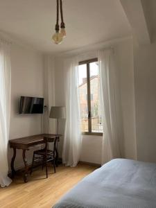 博洛尼亚La Casa in Sant'Apollonia的一间卧室配有书桌、床和窗户。