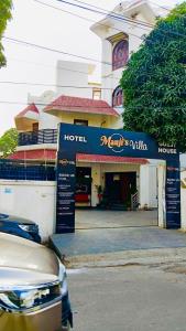 PrayagrajMauji's Villa Hotel & Guest House的建筑前有标志的酒店