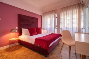 阿威罗D'Ávila Peixinho 180的一间卧室配有一张大床、红色床单和桌子