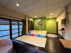 清迈Villa’s Homestay的绿墙客房内的两张床