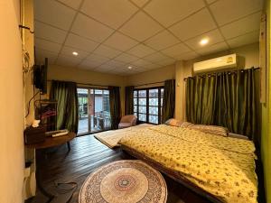 清迈Villa’s Homestay的一间卧室设有两张床、一张桌子和窗户。