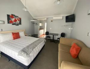 陶波Lakeside Taupo Motel的一间卧室配有一张床和一张沙发