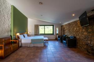 巴尔罗马内斯Hotel Golden Barcelona的一间卧室设有一张床和石墙