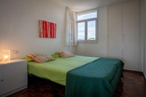 托里代巴拉AT013 Torremunts的一间卧室设有一张带窗户的绿色床