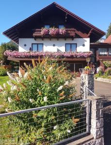 OberortHaus Bergblick的围栏前有鲜花的房子