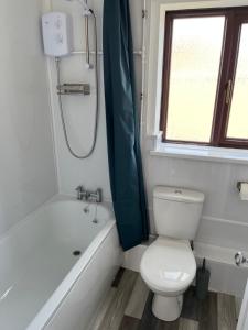 谢林汉姆SeaCross Sheringham Norfolk Coast 3 Bed Detached house的浴室配有卫生间、浴缸和水槽。