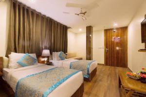 新德里OPO Hotel Viva Palace的酒店客房设有两张床和一张桌子。