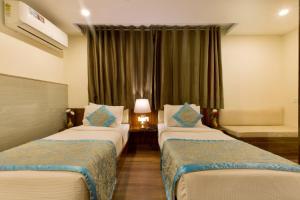 新德里OPO Hotel Viva Palace的酒店客房设有两张床和窗户。