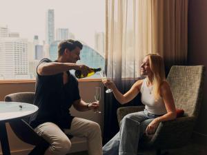 悉尼达令港诺富特悉尼酒店的把一杯酒倒给女人的男人