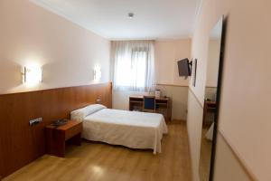 San Román安达穆圣罗曼酒店的配有一张床和一张书桌的酒店客房