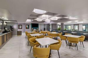 奥拉西奥拉西拉金塔套房酒店的用餐室配有桌子和黄色椅子
