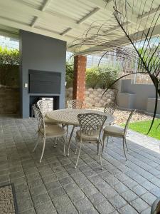 温特和克City comfort self catering Windhoek的庭院配有桌椅和壁炉。