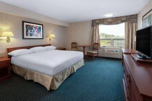 阿默斯特Travelodge by Wyndham Amherst的酒店客房,配有床和电视