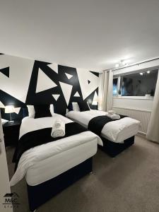 凯特林Kettering/Stylish/ Perfect for Contractors的黑白墙壁客房的两张床