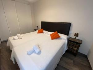 科鲁韦多HOSPEDAJE STOP的一间卧室配有两张白色床和橙色及白色枕头