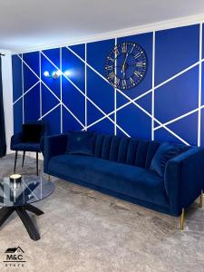 凯特林Kettering/Stylish/ Perfect for Contractors的蓝色的长沙发和蓝墙上的钟