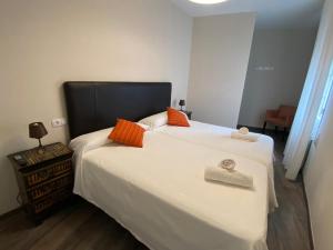 科鲁韦多HOSPEDAJE STOP的卧室配有带橙色枕头的大型白色床