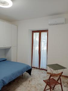 钱皮诺Bici Grill Decimo Miglio的一间卧室配有一张床、一张桌子和一个窗户。