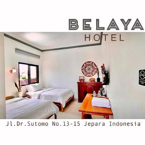哲帕拉Belaya Hotel的酒店客房设有两张床和一张桌子。