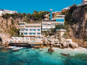 伏罗拉Hotel Liro - Adults Only的水边悬崖上的酒店