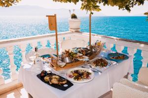 伏罗拉Hotel Liro - Adults Only的俯瞰大海的阳台的餐桌