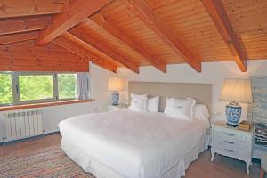卡拉维亚艾尔巴布酒店的卧室设有白色的床和木制天花板。