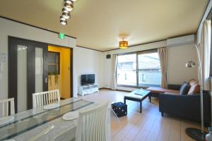 大阪Maple Hotel Osaka的客厅配有桌子和沙发