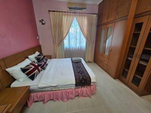 古晋Lovely Luxury Detached House Vivacity Kuching的一间卧室设有一张大床和窗户