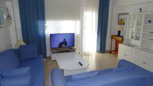 阿尔库迪亚港Mountain View Apartment in Port Alcudia的客厅配有蓝色的沙发和电视