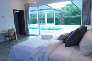春蓬CoaSea Pool Villa - 3 Bedrooms 3.5 Bathrooms的一个带游泳池的房间的一张大白色床