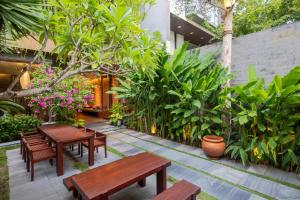 岘港K-House vs Apartment的庭院设有木长椅和植物