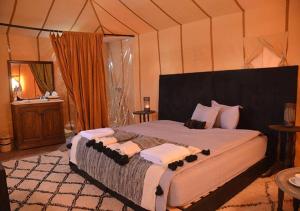 扎古拉Sahara Relax Camps的帐篷内一间卧室,配有一张大床