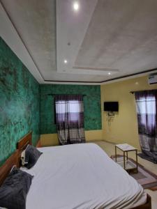 尼亚加Keur Medzo - Lac Rose的卧室设有白色的床和绿色的墙壁