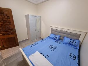 达喀尔Keur Coumba的一间卧室配有一张带蓝色床单和枕头的床。