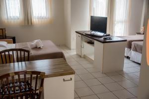 纳塔尔塞兰特斯公寓式酒店的小房间设有一张桌子和一台电脑
