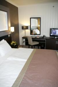 布达佩斯布达佩斯水上世界度假村的酒店客房配有一张床和一张带电脑的书桌