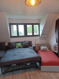 埃夫勒Magnifique studio de charme的一间卧室配有一张床和一张红色的沙发