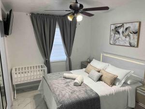 TamiamiCharming 2-Room Oasis - Miami的一间卧室配有一张带吊扇的床