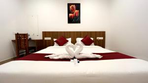 KattappanaHotel Dream Suite, Kattappana的一间卧室,床上配有2条天鹅毛巾