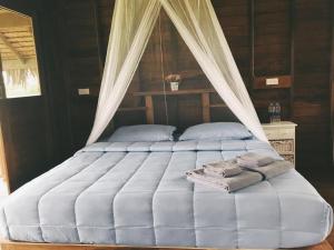 阁遥岛NammNatawn2的一张带天蓬的床,上面有两个枕头