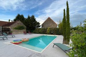 Nohant-VicMaison à proximité du village de George Sand的一个带椅子的庭院和房子的游泳池