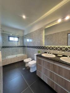 科连特斯Casa Quinta Laguna Brava 2. Bitcoins House.的浴室配有2个盥洗盆、卫生间和浴缸。