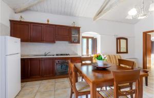 圣乔瓦尼·罗通多1 Bedroom Gorgeous Apartment In San Giovanni Rotondo的厨房配有木桌和白色冰箱。