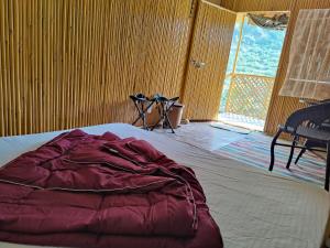 DāngchuraMoupiya Resort and Restaurant的一张位于带大窗户的房间内的床铺