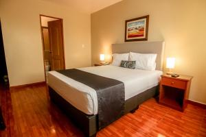 利马Epiqus Hotel的酒店客房设有一张大床和两盏灯。