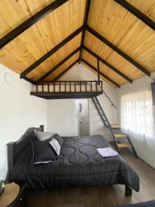 蒙圭Hospedaje - Cabañas villa rosita的一间卧室设有一张黑色床和木制天花板
