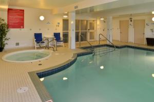 埃德蒙顿Holiday Inn Express Edmonton North, an IHG Hotel的一个带桌椅的大房间中的游泳池