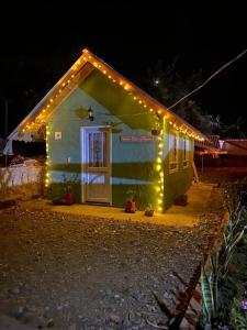 蒙圭Hospedaje - Cabañas villa rosita的一间晚上有灯的小房子